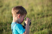 Little boy with camera outdoor