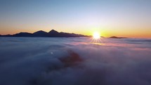 Peaceful morning Fly above low clouds in alpine mountains nature scenery at beautiful sunrise panorama
