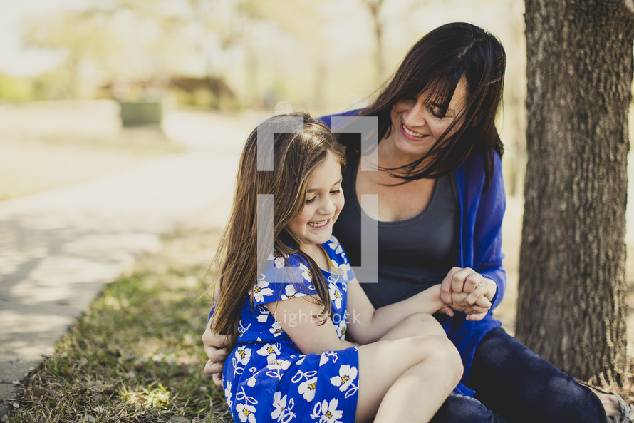 mother and daughter sitting together outdoors