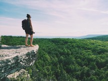 woman standing at the edge of a mountainside 