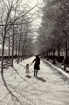 mother walking with her daughter  in a park