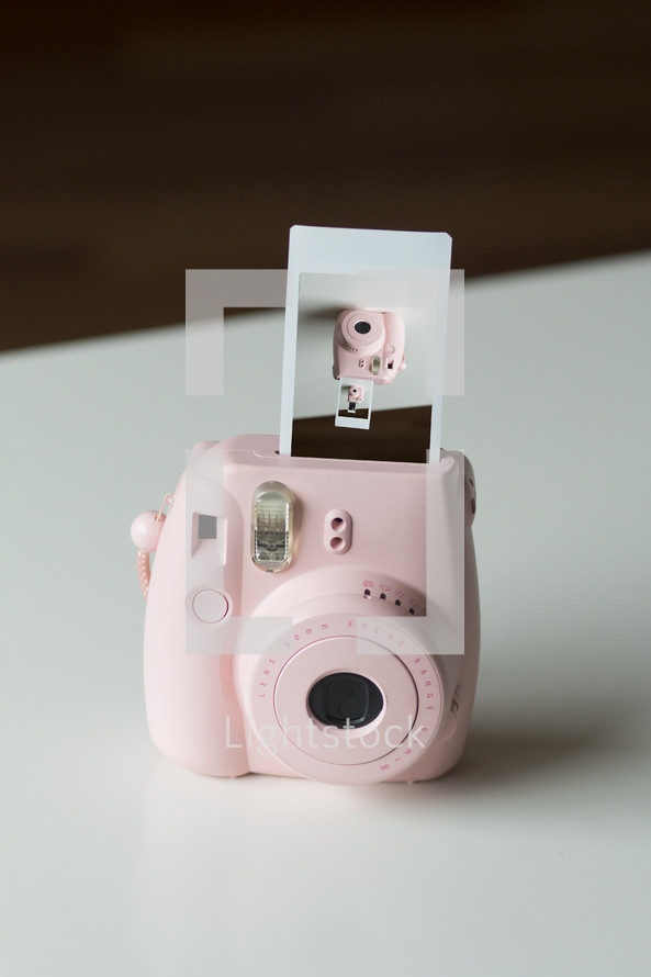 Pink Instant Camera with Film Coming Out Showing Shot of Camera