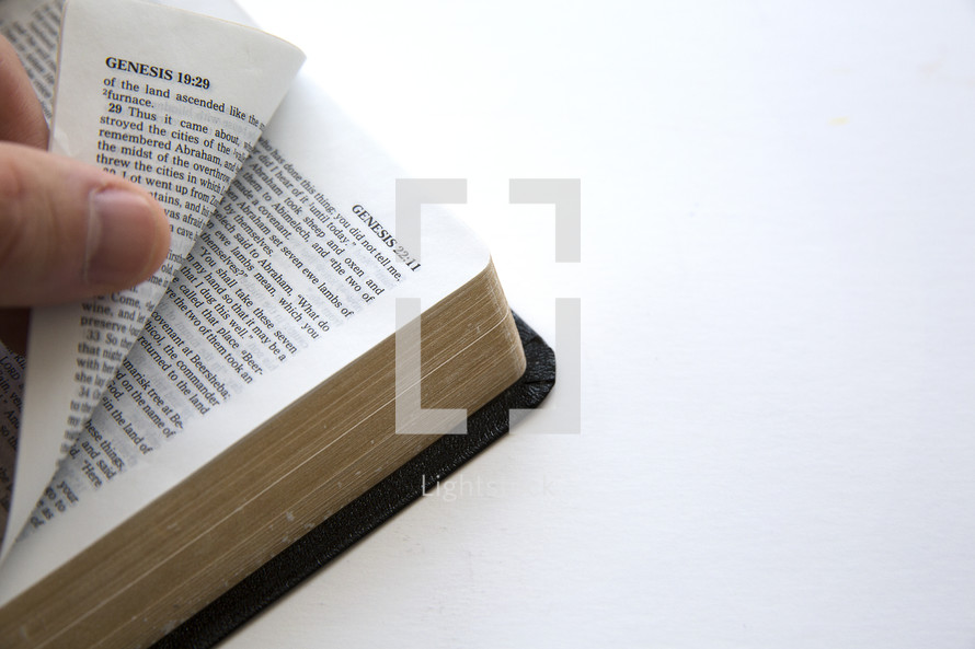 hand turning the pages of a Bible.