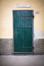 A green door in a stucco wall.