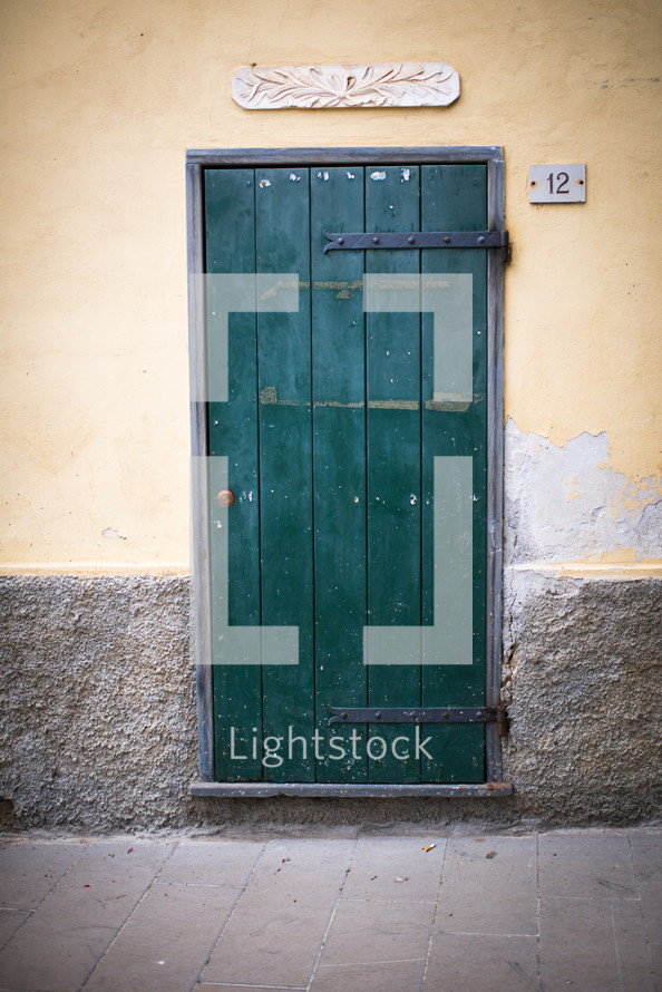 A green door in a stucco wall.