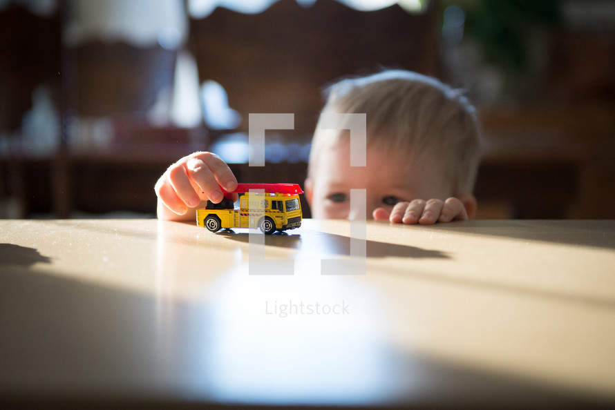 toddler boy with a toy firetruck 