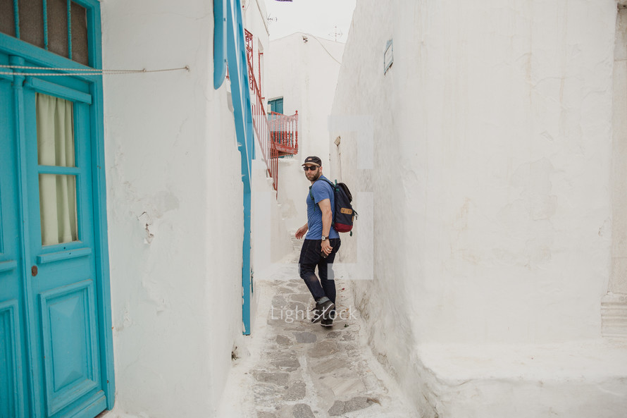 man walking in a narrow alley in Greece 