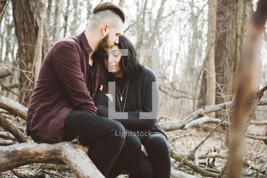 couple sitting together outdoors in the woods 