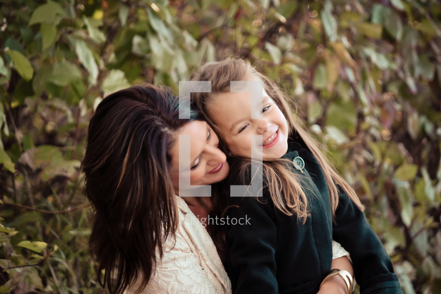 Mother embracing daughter with laughter.