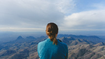 a woman looking out at mountains 