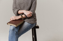 woman sitting on a stool with a Bible in her lap