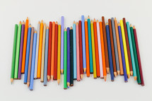 row of colored pencils on a white background 