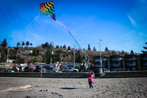 girl flying a kite in a coat 