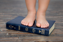 a child standing on a Bible - foundation in God