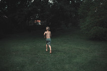 a boy running through a lawn 