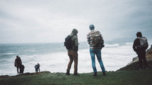 men standing along the edge of cliffs along a shore 