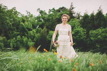 Bride with flower bouquet in field