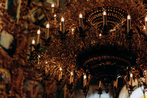 Modern lamps are like candles. gold-plated chandelier hangs in the old church near the icons. Modern lamps are like candles.