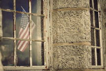 An American flag through an old school building window 