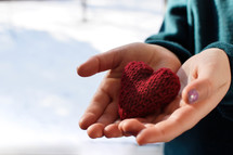 cupped hands with a knit heart 
