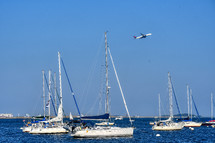 airplane over sail boats in Boston Harbor 