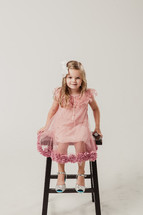 girl child sitting on a stool 