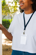 Woman in a white tshirt wearing a lanyard.