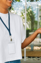 Woman in a white tshirt wearing a lanyard.