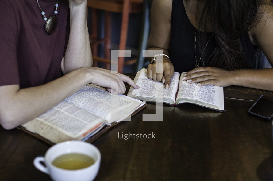 women reading Bibles around a table at a Bible study 