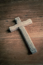 Wooden cross on a wooden table.