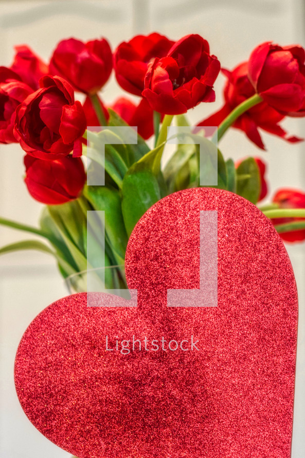 vase of Valentine's Day red tulips and red heart with copy space 
