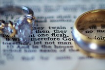Wedding rings lying on a page of the bible - Mark 10:8