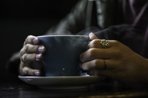 a girl holding a steaming cup of coffee at a Bible study 