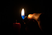 lighting a candle with a lighter 