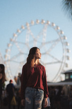 woman with a ferris wheel in the background 