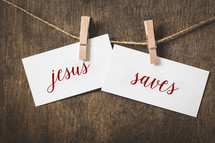 words Jesus saves on white card stock hanging from a clothespin on a clothesline 