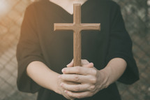 a woman holding a wooden cross