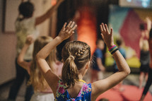 children dancing with hands raised 