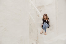 woman sitting on white steps in Greece 
