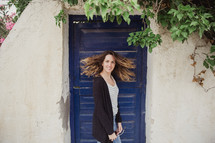 woman shaking her head in front of a blue door in Greece 