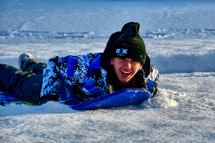 teen boy on a sled in snow 