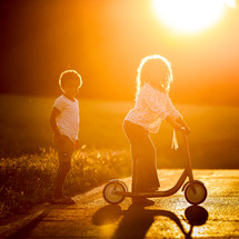 kids with a scooter in warm sunlight 