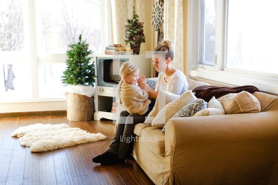 mother and daughter sitting on a couch 