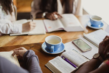 women reading Bibles and drinking coffee at a Bible study 