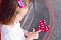 girl child holding a heart 