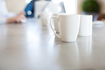 coffee mugs on a conference table 