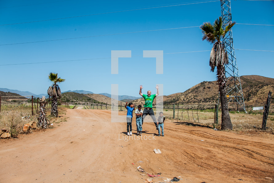 man and children on a dirt road in Mexico 
