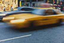 A blurred yellow cab driving by