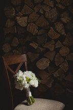 bouquet in a chair in front of a wood pile