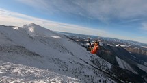 Paragliding fly high above winter alpine mountains in freedom adrenaline adventure
